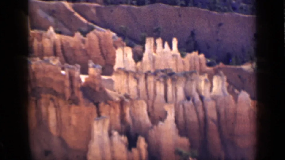 1939 Utah 8mm frame with cream hoodoo formations and vertical erosion lines across the canyon face.