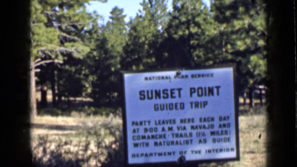 1939 Utah home-movie frame of the Sunset Point Guided Trip notice, including Navajo and Comanche Trails text.