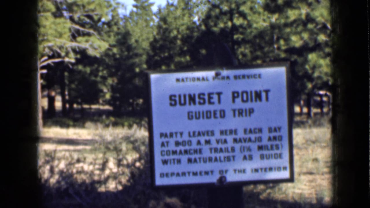 1939 Utah 8mm view of a National Park Service Sunset Point sign framed by dark film edges and forest vegetation.