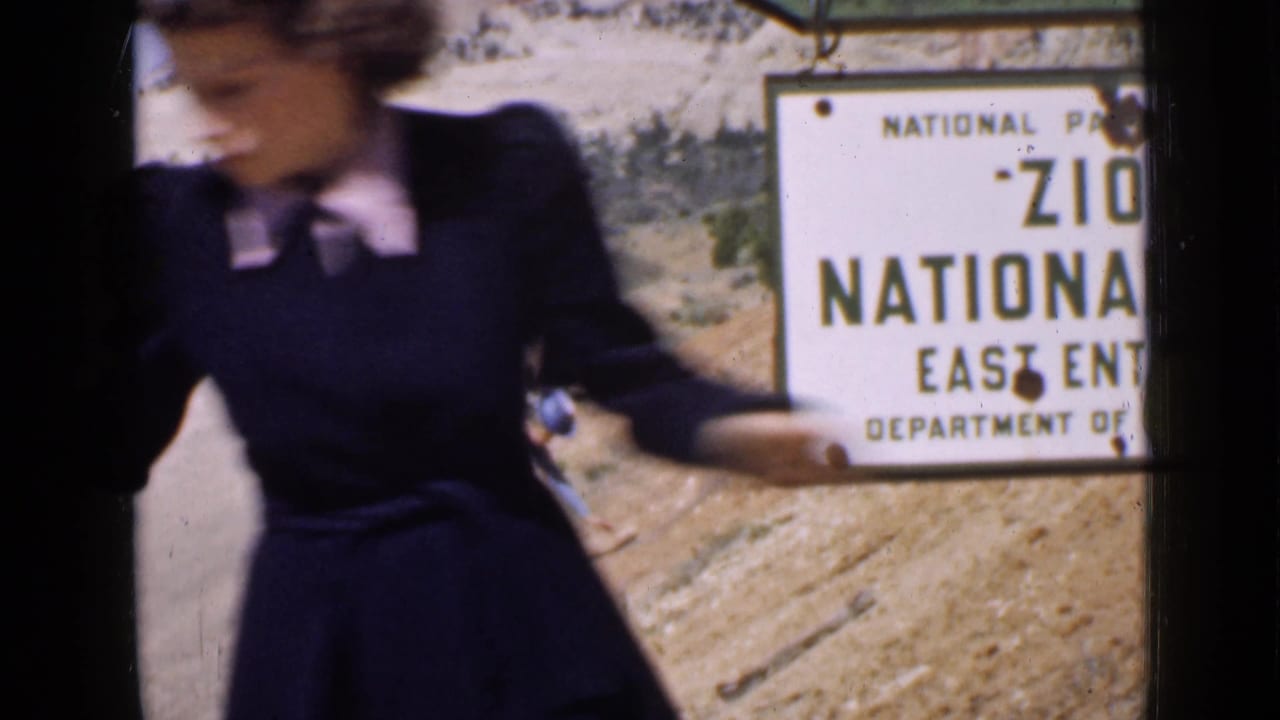 The 1939 home-movie frame shows the woman very close to camera, partially obscuring the Zion National Park East Entrance sign.