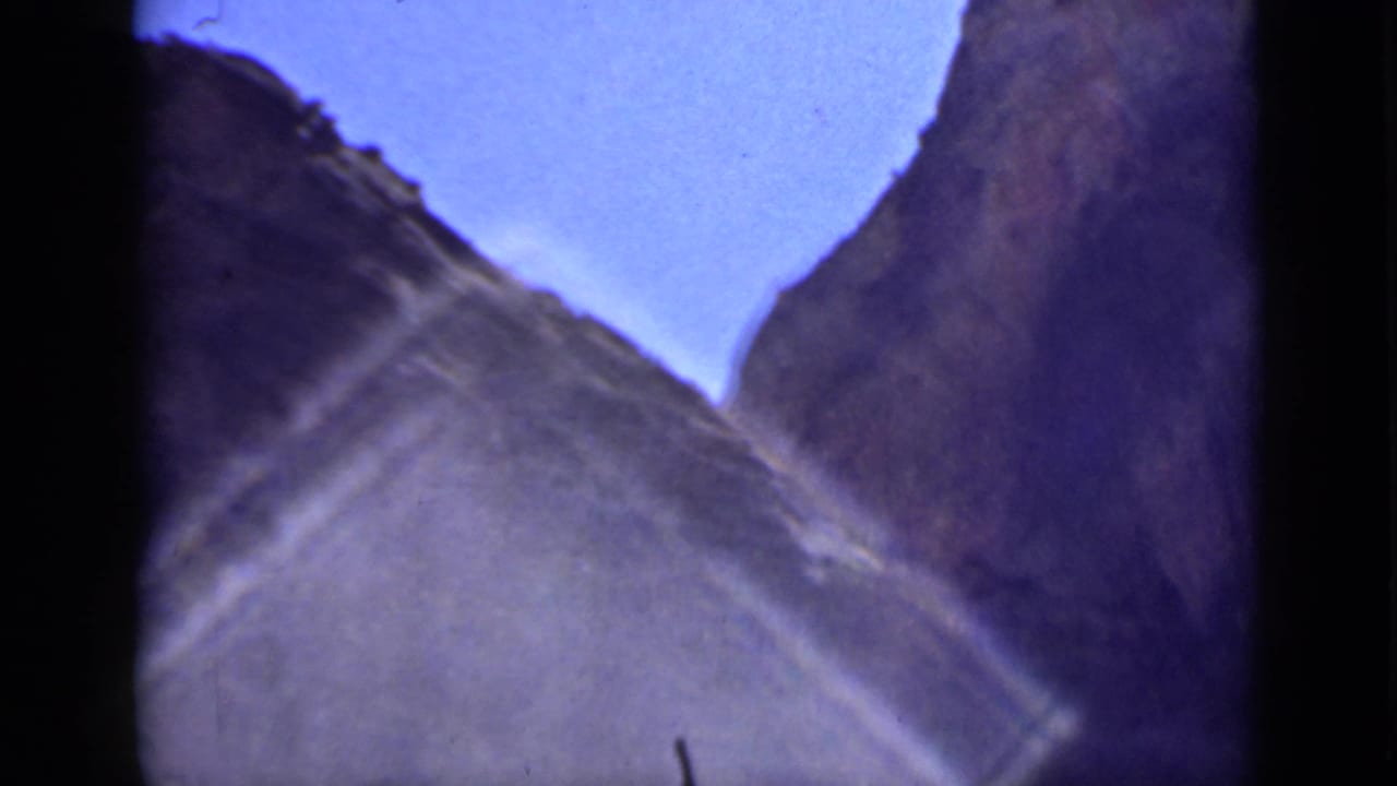 Soft 8mm view of steep canyon walls and blue sky.