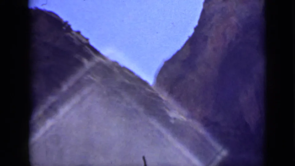 1939 Utah home-movie frame showing steep canyon walls with a narrow opening of blue sky above.