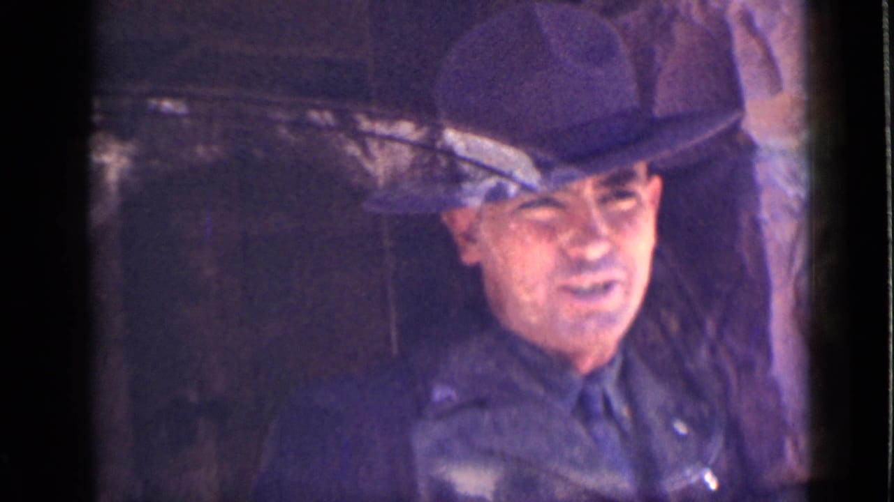 Brief 1939 Utah 8mm frame of an adult man in a dark brimmed hat and dark clothing inside the vehicle, with visible face detail.