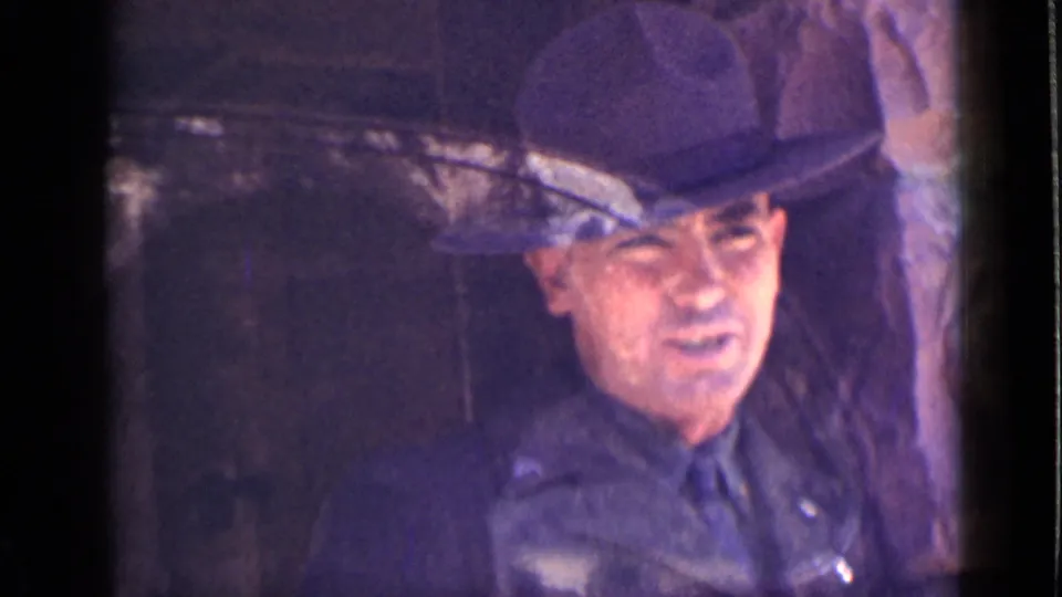 Brief 1939 Utah 8mm frame of an adult man in a dark brimmed hat and dark clothing inside the vehicle, with visible face detail.