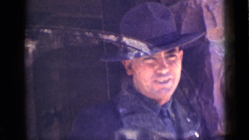 In 1939 Utah footage, a likely park ranger in a dark uniform and broad-brimmed hat looks out from inside a tower window.