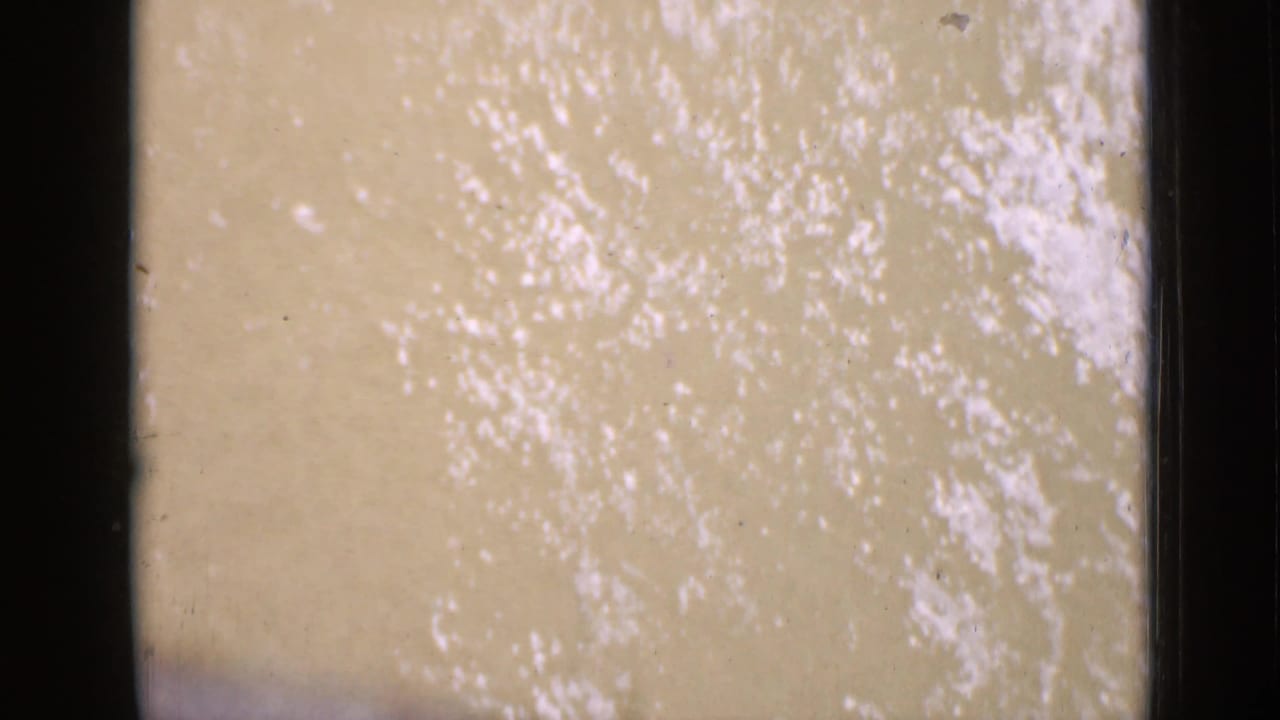 A pale, textured river surface appears in the lower frames, bordered by dark film gate edges and 8mm grain.