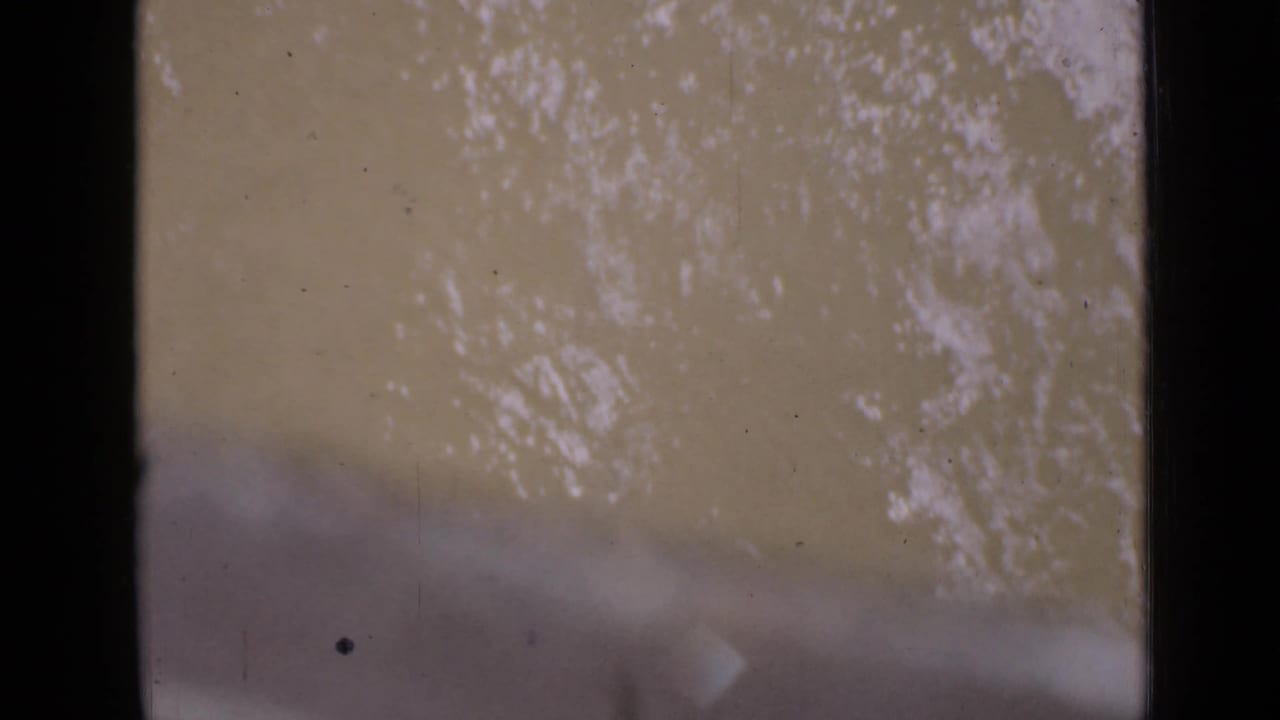 The final 8mm frame shows river texture with a pale, leader-like flare or end-of-roll exposure across the lower portion.