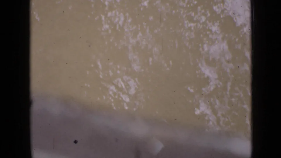 The final 8mm frame shows river texture with a pale, leader-like flare or end-of-roll exposure across the lower portion.