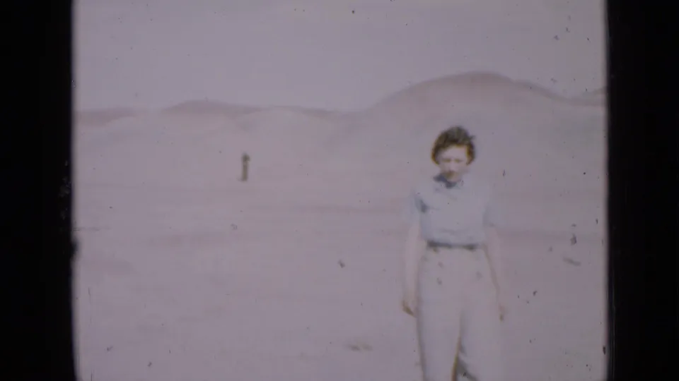 Young woman in light clothing stands in a Utah desert landscape, filmed in soft 1939 8mm home-movie color.