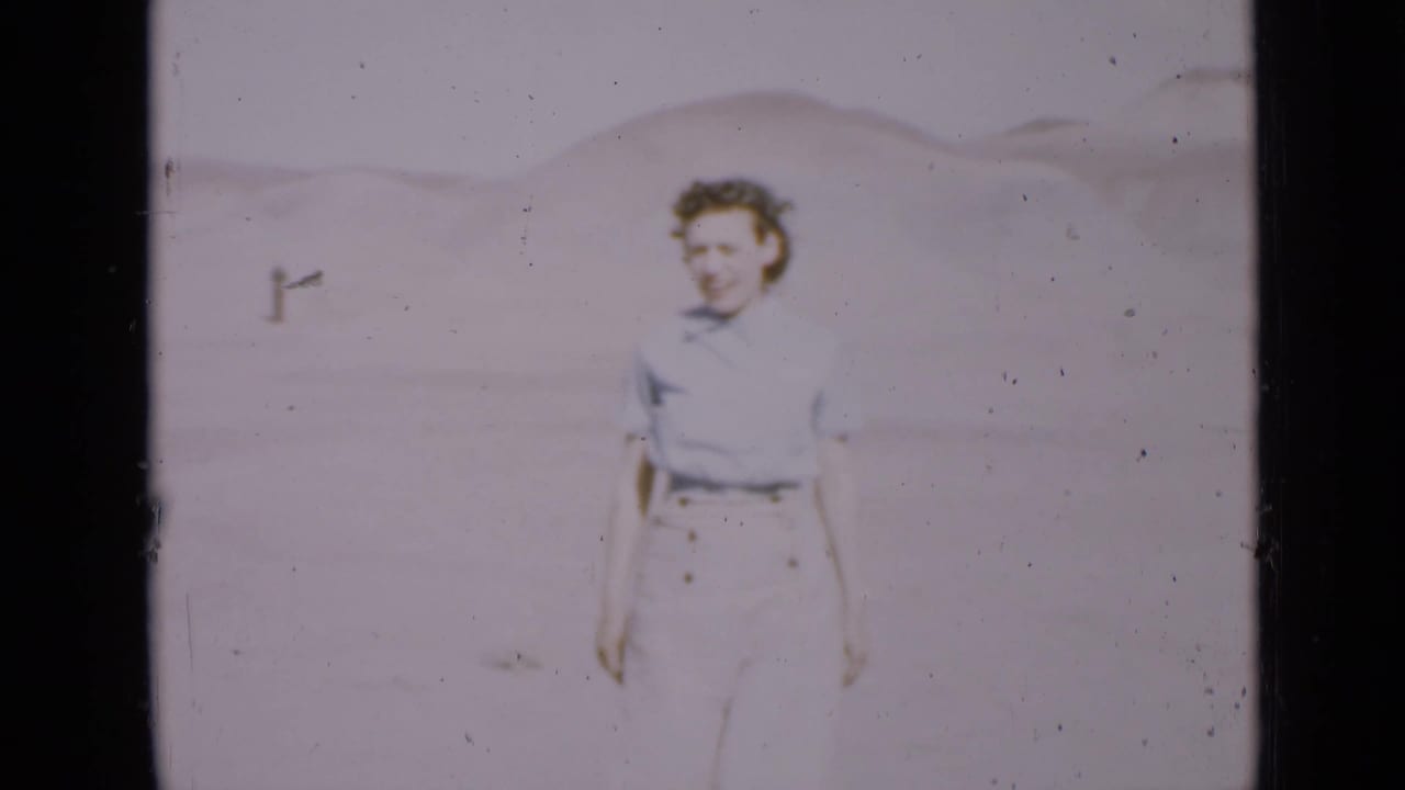 Woman walking closer to the camera with desert hills in the background.