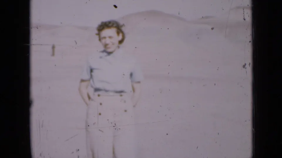 Young woman appears to smile while standing in a Utah desert landscape, captured in faded 1939 8mm film.
