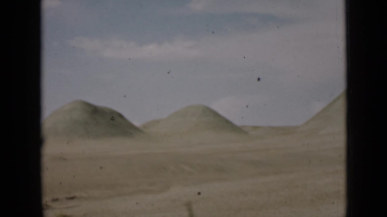 Low sand hills across a flat desert under a pale sky.