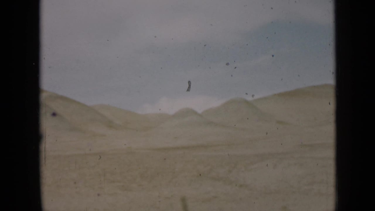 Utah desert hills under a pale sky in 1939 8mm home-movie footage, with visible dust and frame edges.
