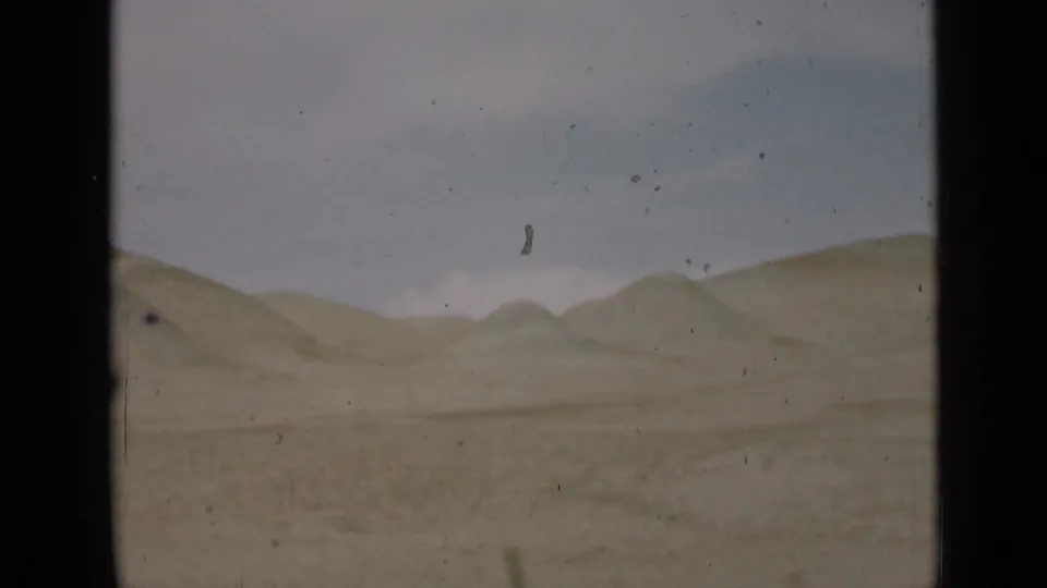 Utah desert hills under a pale sky in 1939 8mm home-movie footage, with visible dust and frame edges.