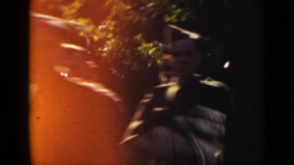 End frame from the 1940 Ontario 8mm clip, partly obscured by flare and shadow with a garden path or planting edge still visible.