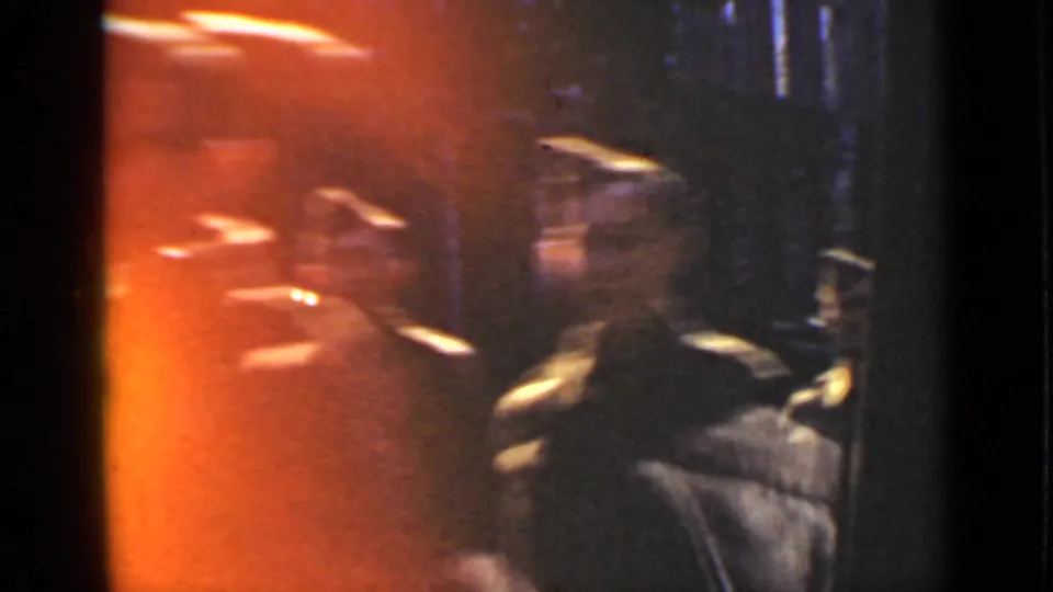 1940 Ontario frame with orange film flare over blurred soldiers and reflective street-side glass.