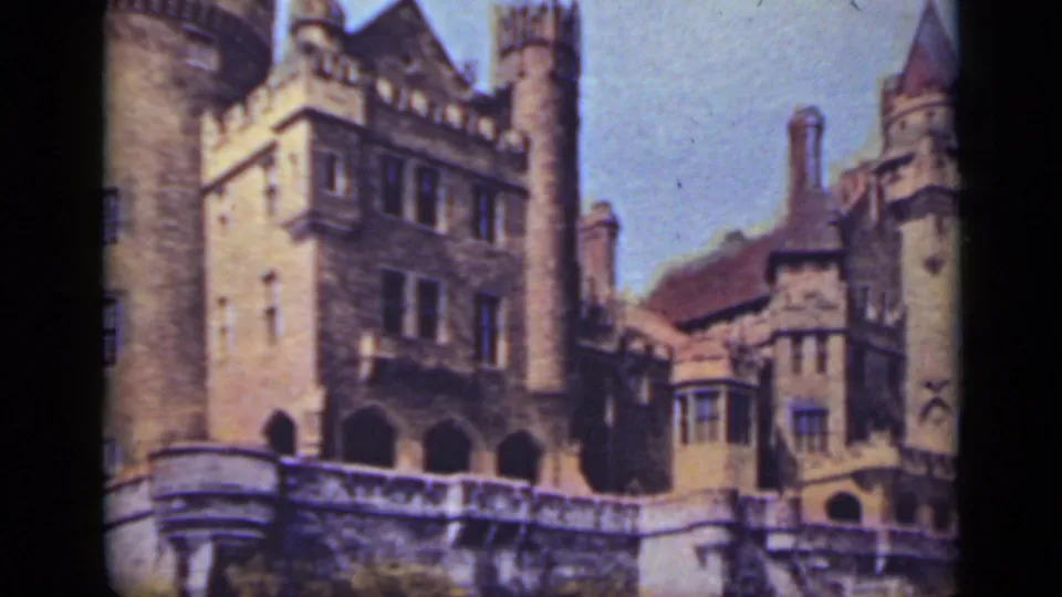Visitor-shot 1940 Ontario view of Casa Loma's castle-style exterior, including stone towers, turrets, windows, arches, and terrace wall.