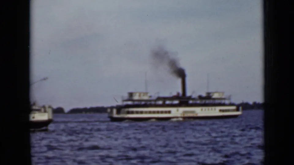 A 1940 Ontario lake scene shows the steam ferry crossing frame while a smaller boat enters at the left edge.
