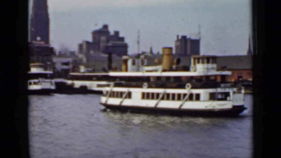 White passenger ferry moving across the water, backed by Ontario waterfront buildings and a soft 1940 home-movie skyline.
