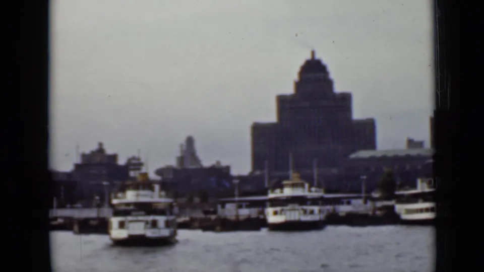 Final 1940s Ontario harbor view with ferries lined near docks and the domed waterfront building behind them.