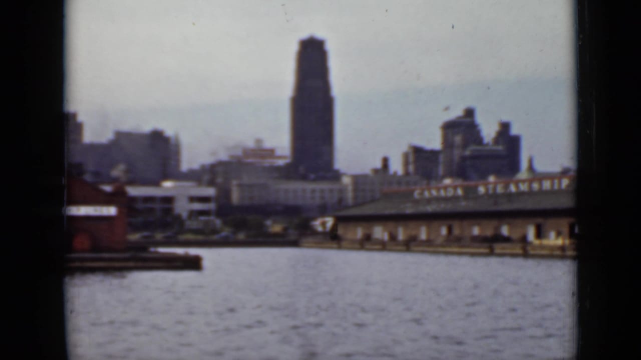 Waterfront wharf with Canada Steamship Lines signage and city skyline beyond the water.
