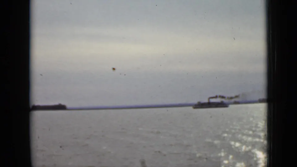 1940 Ontario river view with a distant smokestack vessel crossing open water under a pale sky.