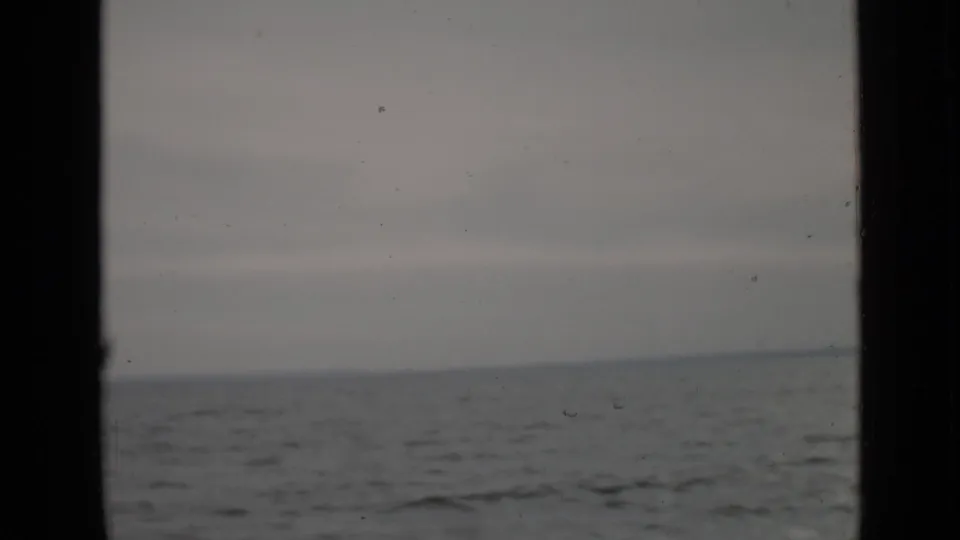1940 Ontario lakeside footage with a dark central frame edge, soft horizon, gray water, and heavy cloud cover.