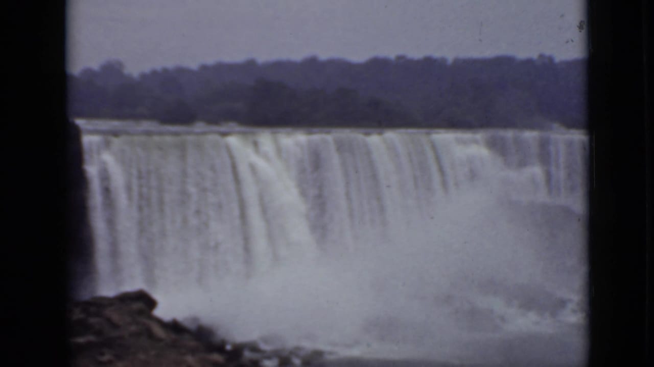 American Falls seen across water with mist and a dark film-frame border.