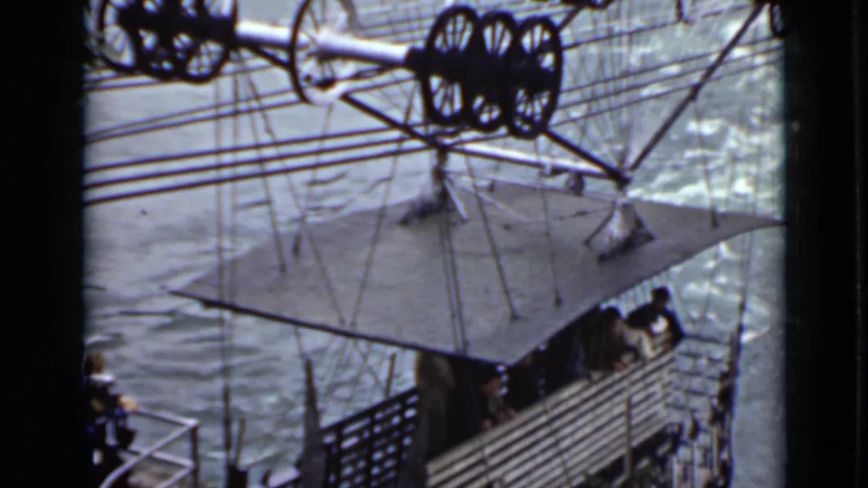 The final frame holds on a waterfront structure with cables, large wheels, railings, and a platform seen from above.