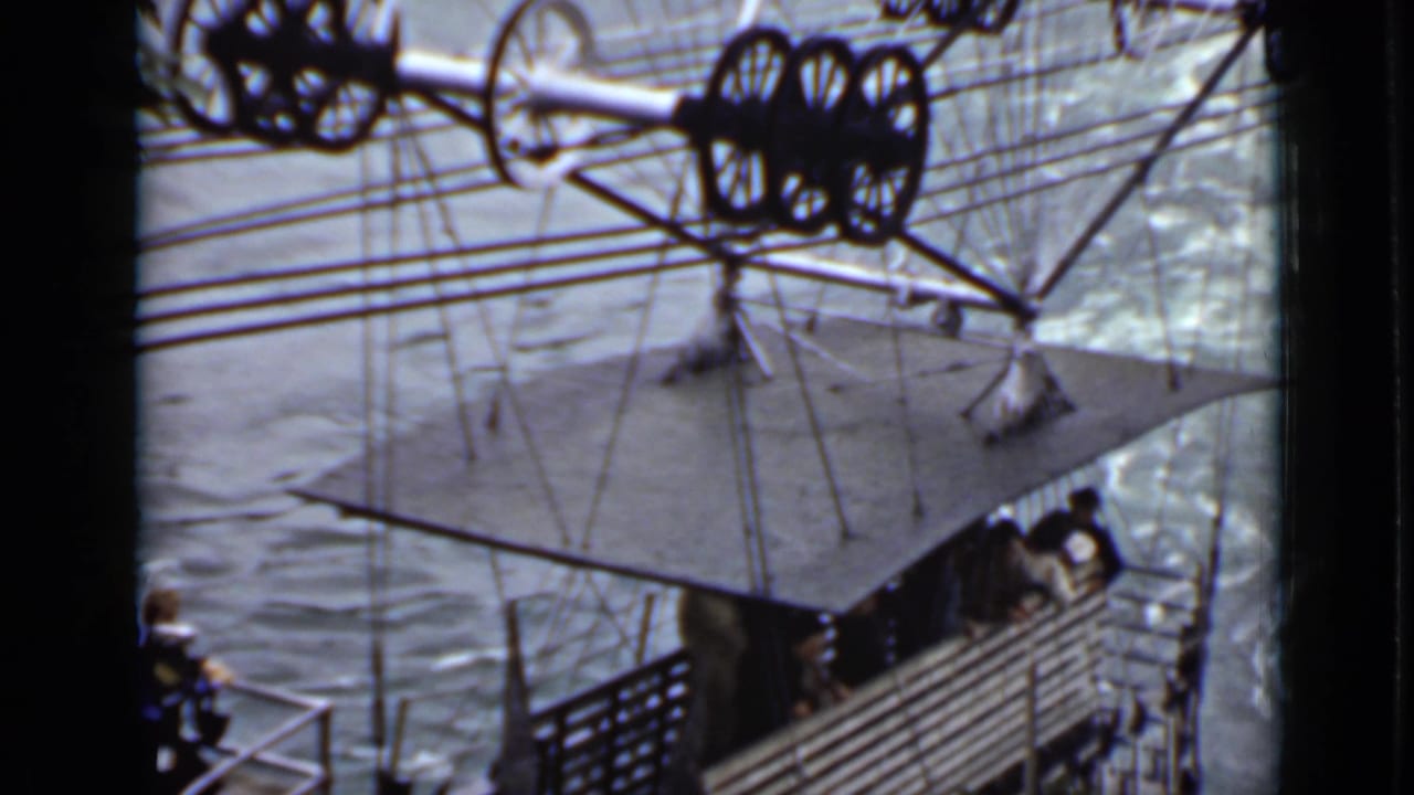 Open cable gondola carrying passengers over churning river water.
