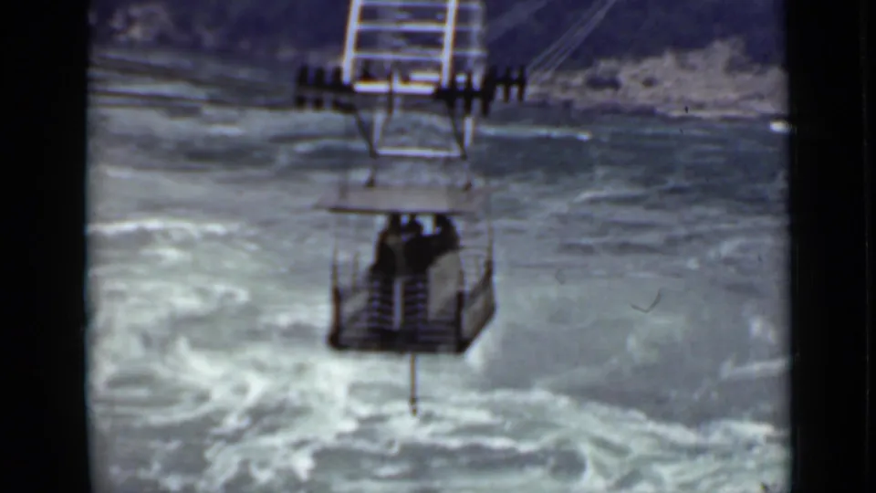 Ontario home-movie frame from 1940 showing the cable car farther along its route over swirling water.
