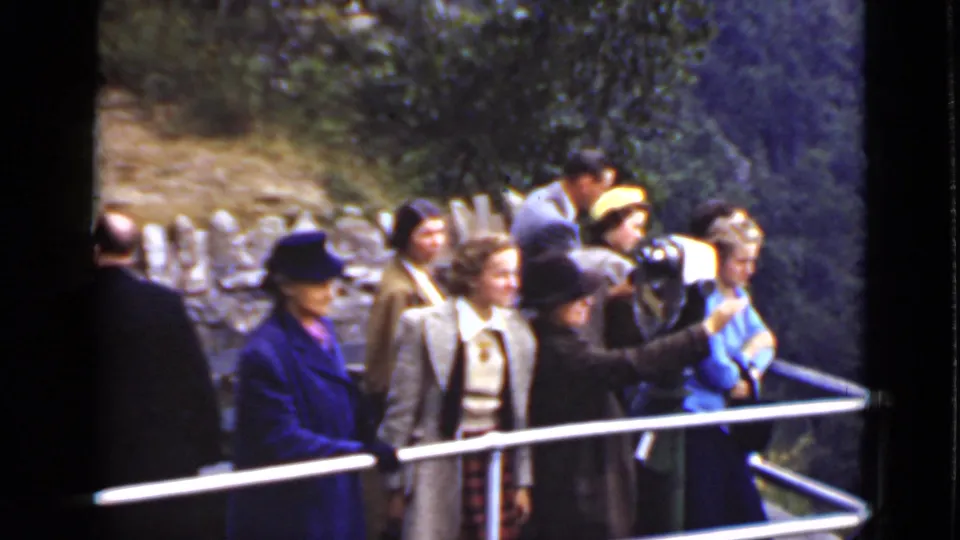 Adults at an Ontario scenic overlook stand along a metal railing as a woman in dark clothing points toward the view.