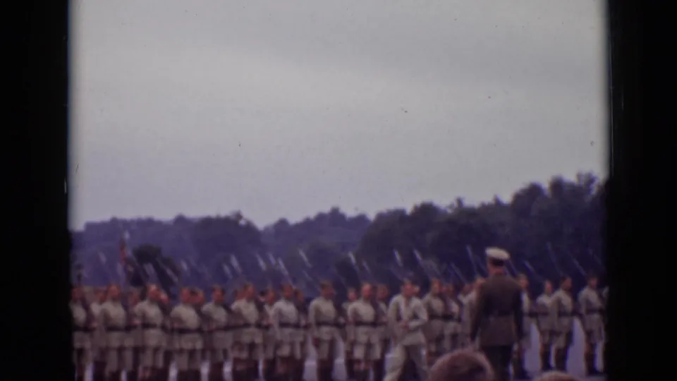 Handheld 1940 Ontario home-movie view of a military line as an officer walks near soldiers with bayonets.