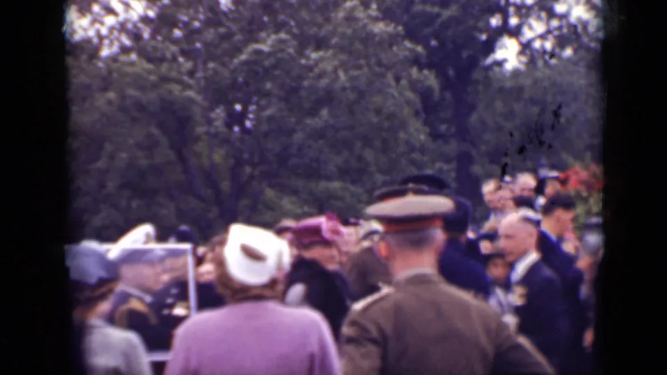 Crowded 1940 Ontario outdoor scene with women in hats, trees, and men in military-style uniforms gathered nearby.
