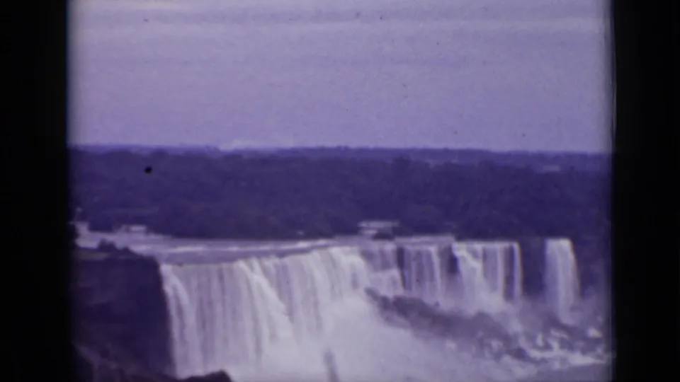 1940 8mm home-movie frame showing Niagara Falls in Ontario from a high overlook, with broad cascades, mist, and a dark horizon.