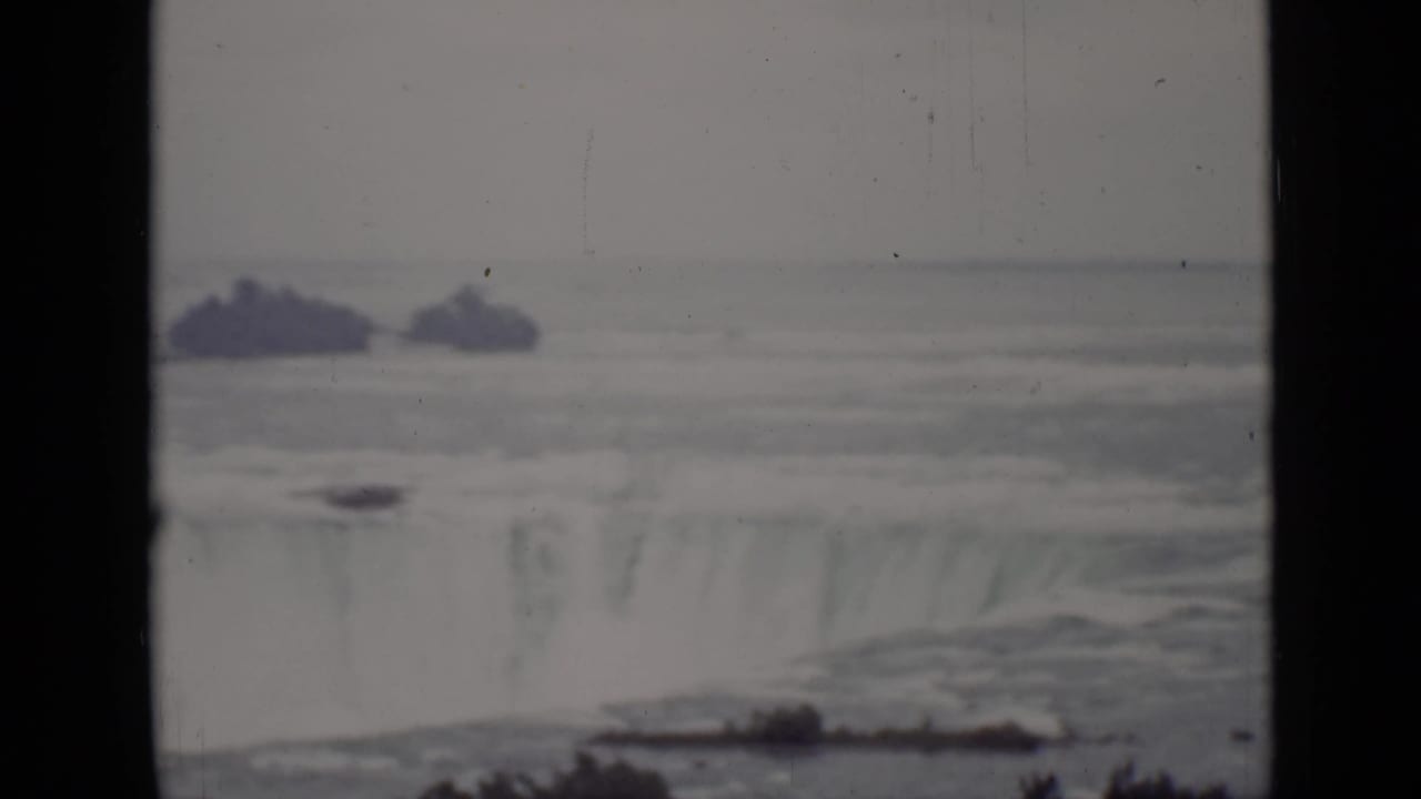 Distant waterfall and river seen through dark 8mm frame edges.