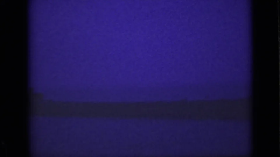 Final purple-toned 8mm frame from the Ontario Niagara view, showing a dim river surface and low horizon line.