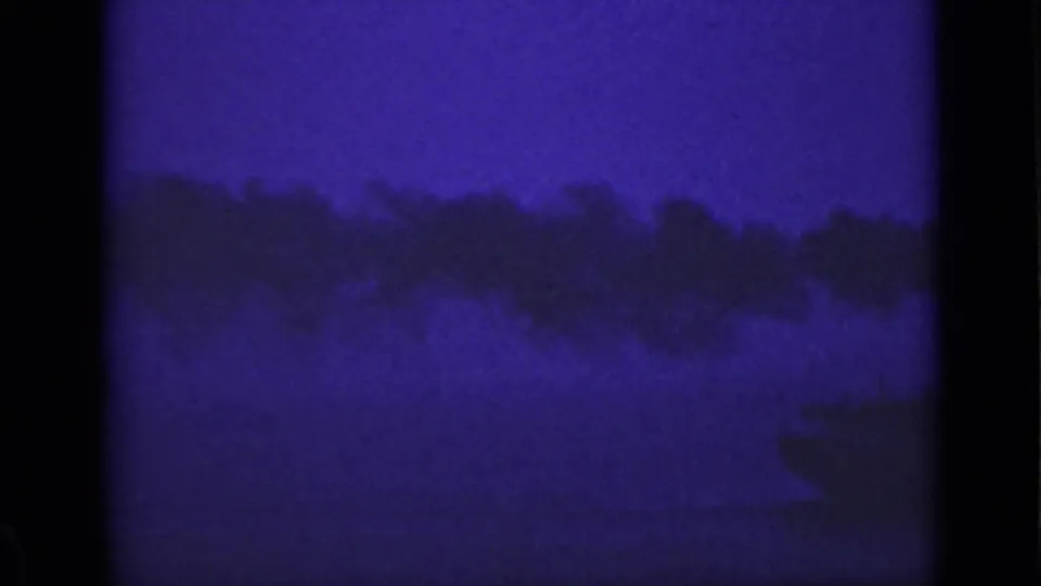 Low-light 1940 Ontario water scene with a smoke plume crossing the frame and only faint vessel detail visible.