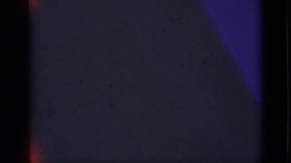 Dark 8mm frame from the 1940 Ontario reel, showing little detail beyond purple-blue exposure, grain, and film borders.