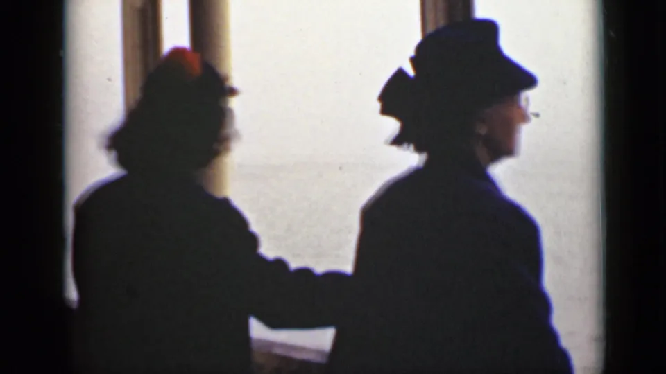 Two adult figures in hats are silhouetted inside a bright Ontario interior, with facial details obscured by backlighting.