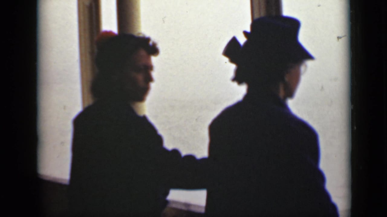 Two women remain silhouetted at a window, one facing outward and one partly turned.