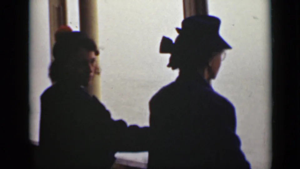 One woman turns enough to show part of her face while another remains facing the bright waterfront window.
