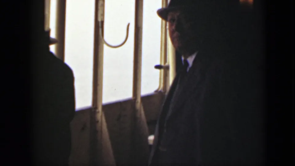The 1940 Ontario vessel interior remains dim, with a fedora-wearing passenger silhouetted against bright foggy window light.