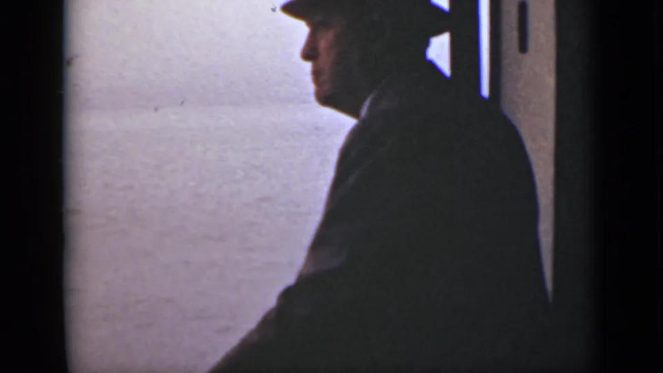 A profile view shows the fedora-wearing man near a boat doorway or window, with pale water filling the background.