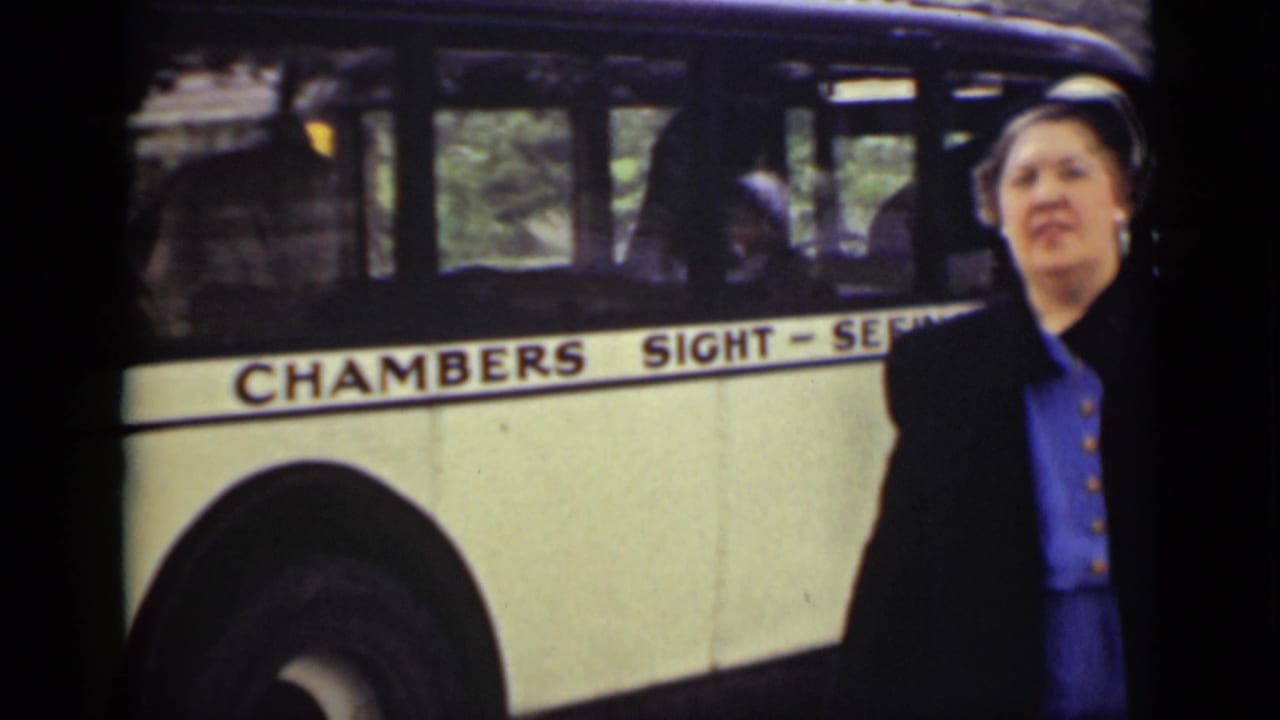 Woman stands close to a Chambers Sight-Seeing bus with passengers inside.