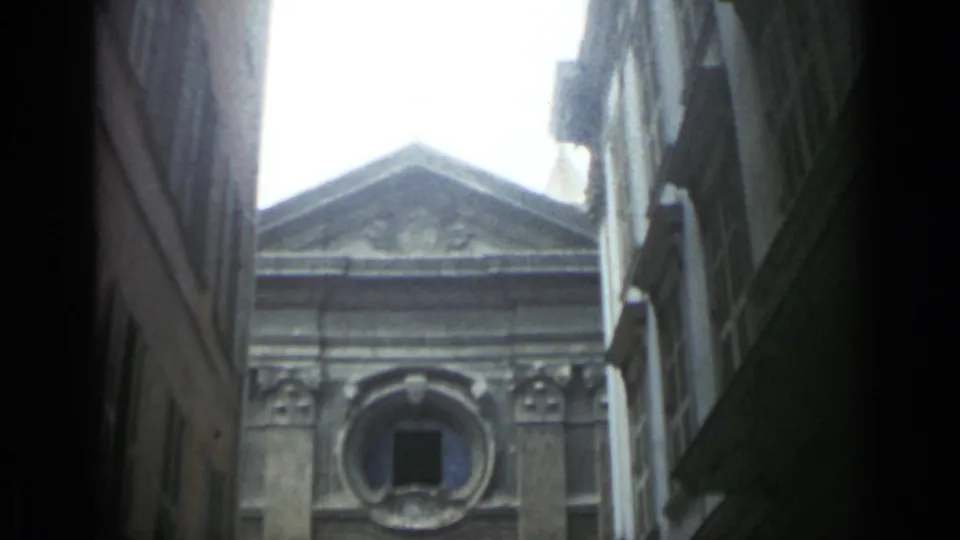 Final 1962 Cannes frame holds on the upper historic facade, framed by alley walls and overexposed sky.