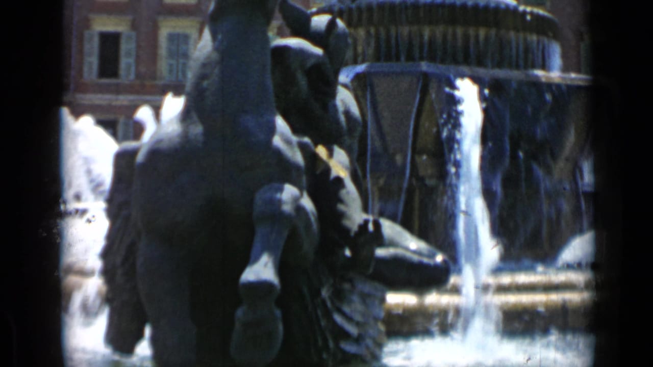 Rear view of a rearing horse sculpture beside cascading fountain water.