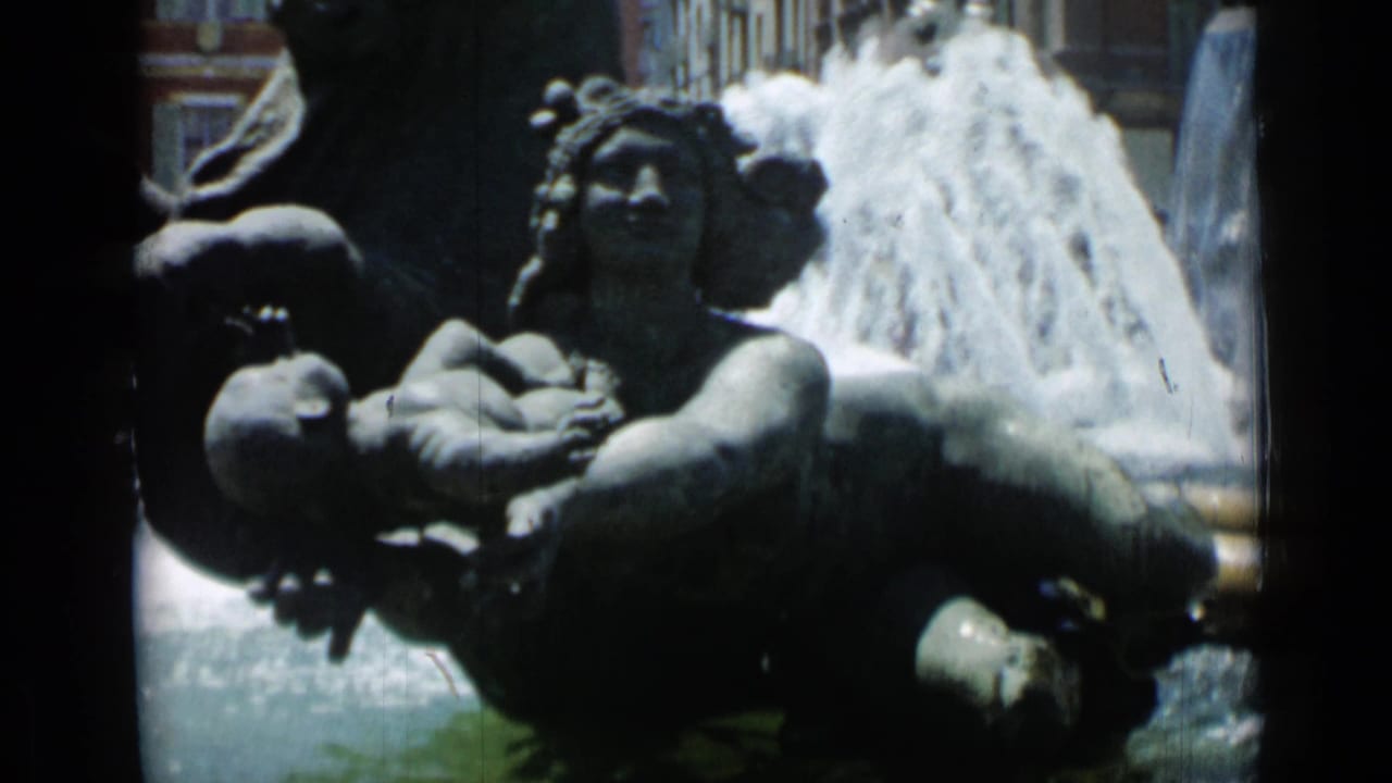 Cannes 1962 8mm view of sculpted figures at a public fountain, with water arcing behind the group.