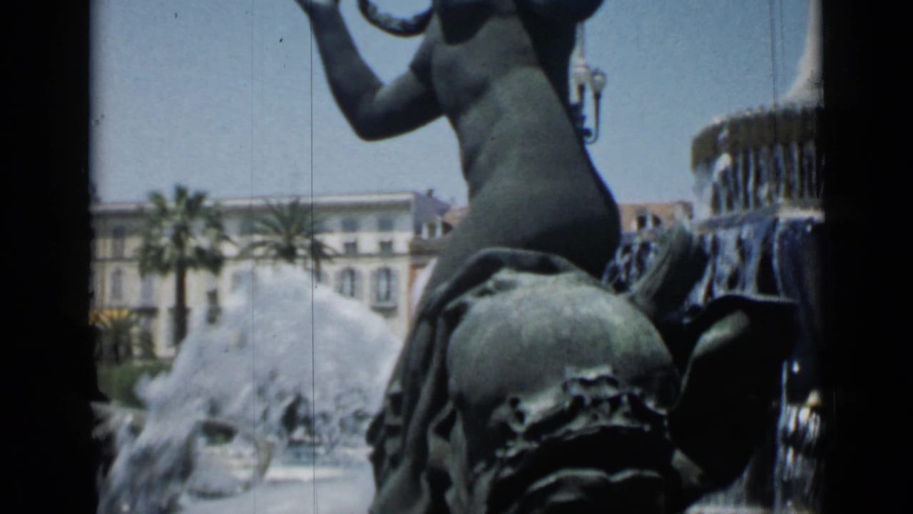 1962 Cannes frame with the bronze horse-and-figure fountain partly filling the foreground as water jets cross the background.