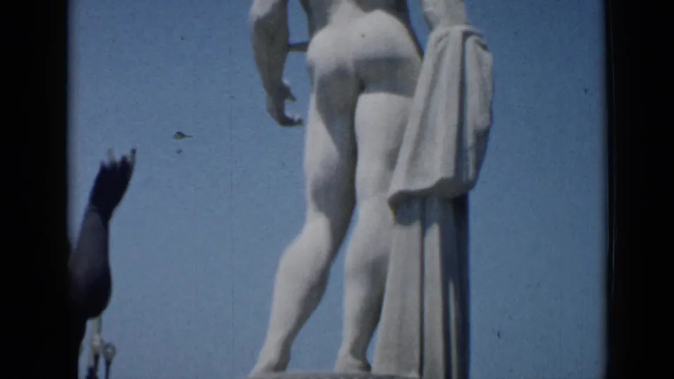 1962 Cannes frame showing the rear of a pale classical nude statue standing over the fountain.